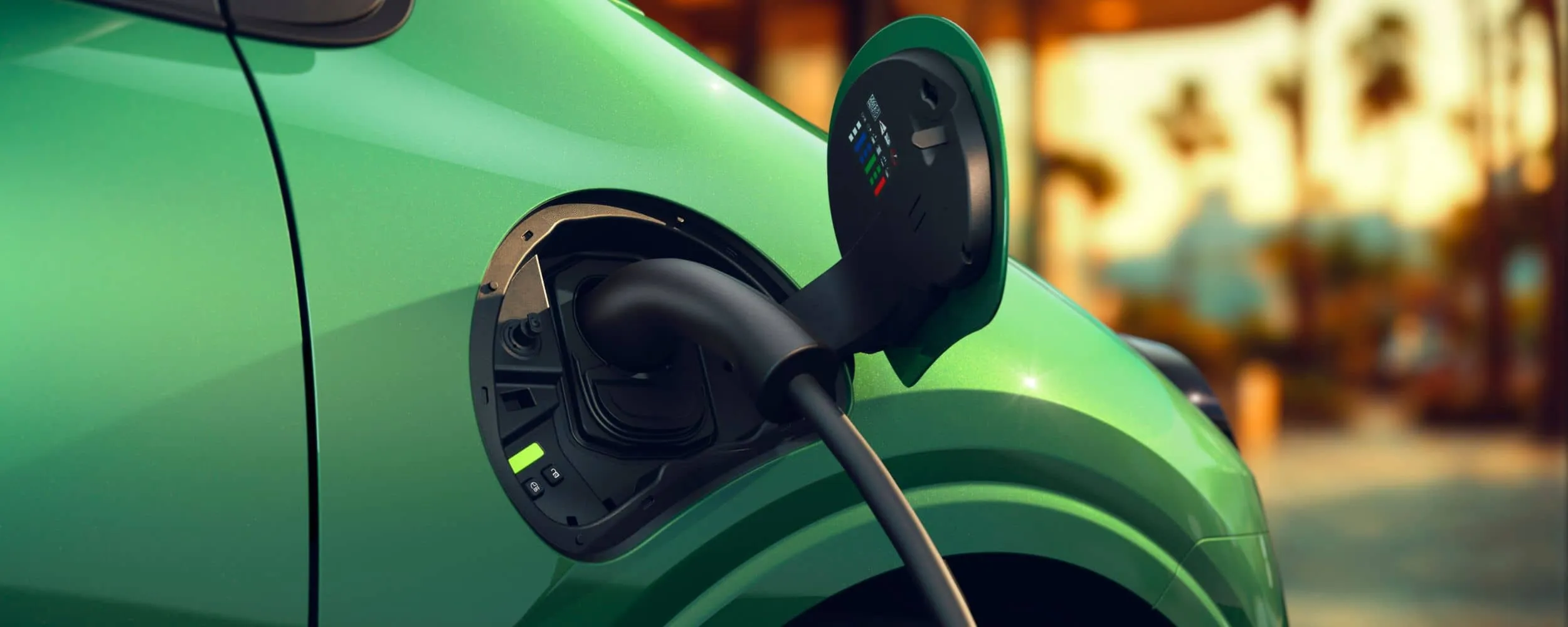 Primer plano de cómo cargar un coche eléctrico en un Renault Twingo verde. Primer plano de cómo cargar un coche eléctrico en un Renault Twingo verde.