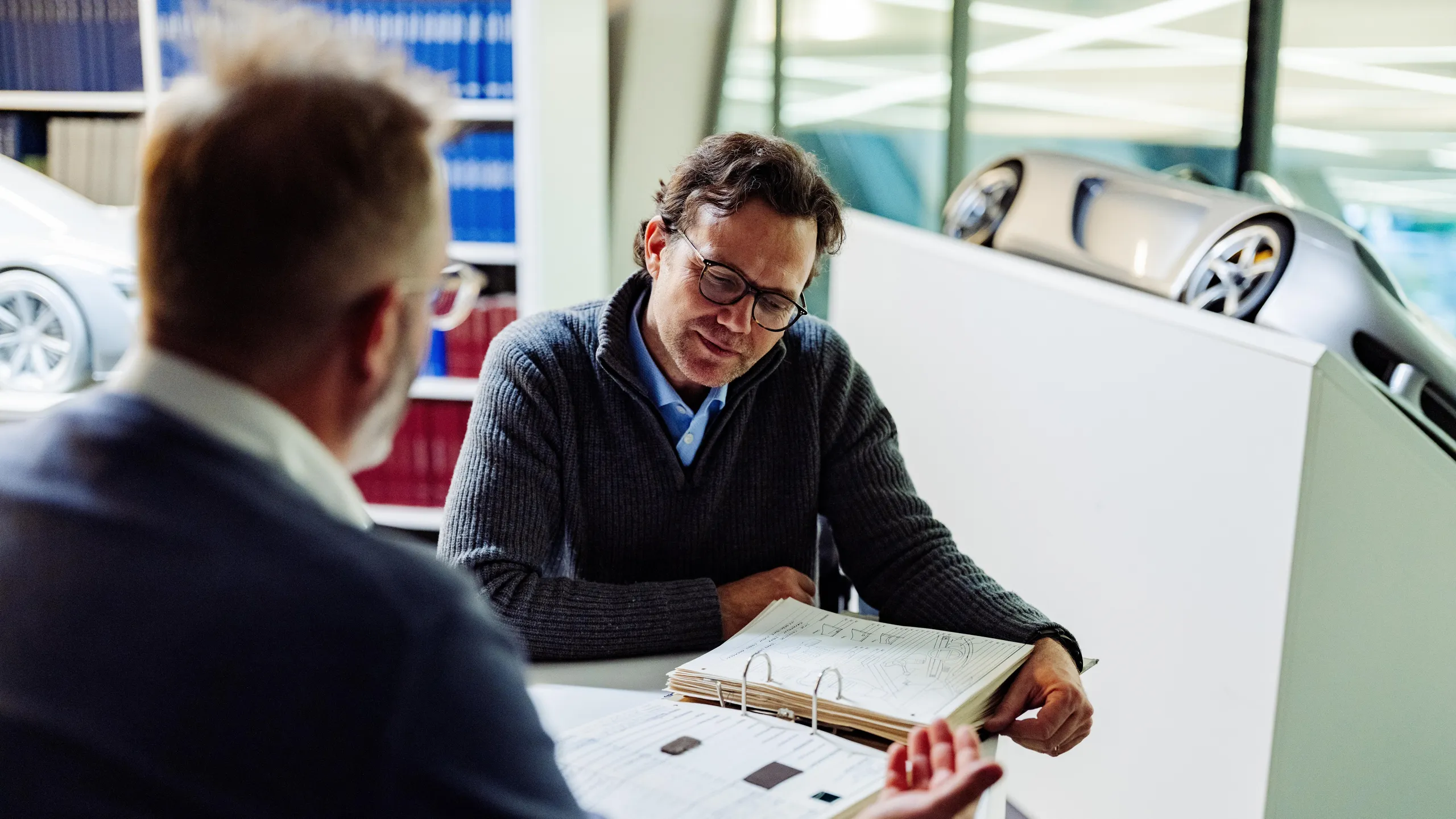 Cliente recibe asesoría en un concesionario sobre trámites para vender un coche heredado. Cliente recibe asesoría en un concesionario sobre trámites para vender un coche heredado.